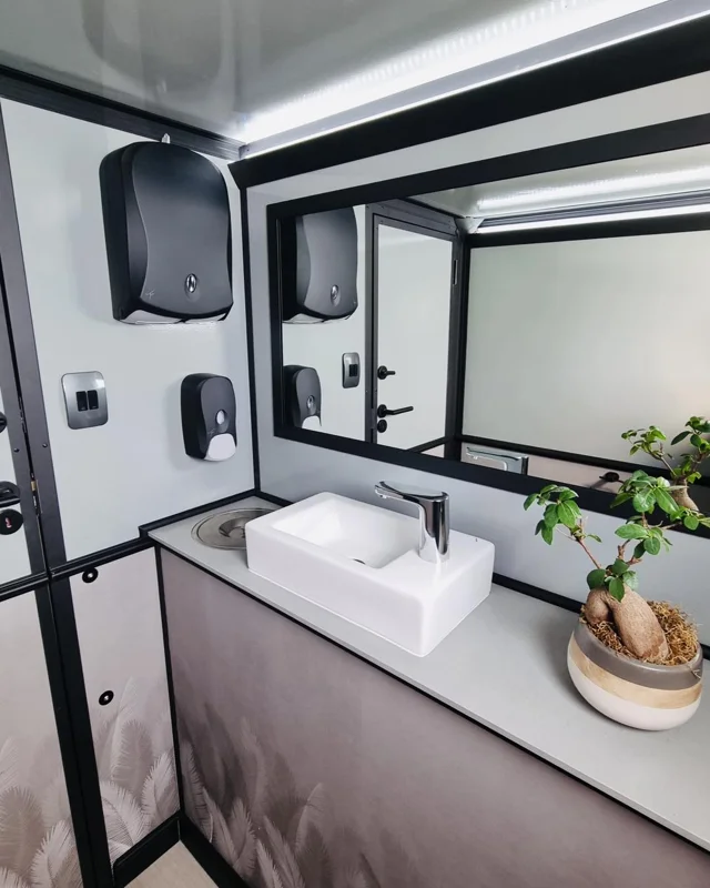 Restroom trailer vanity with a sink and mirror